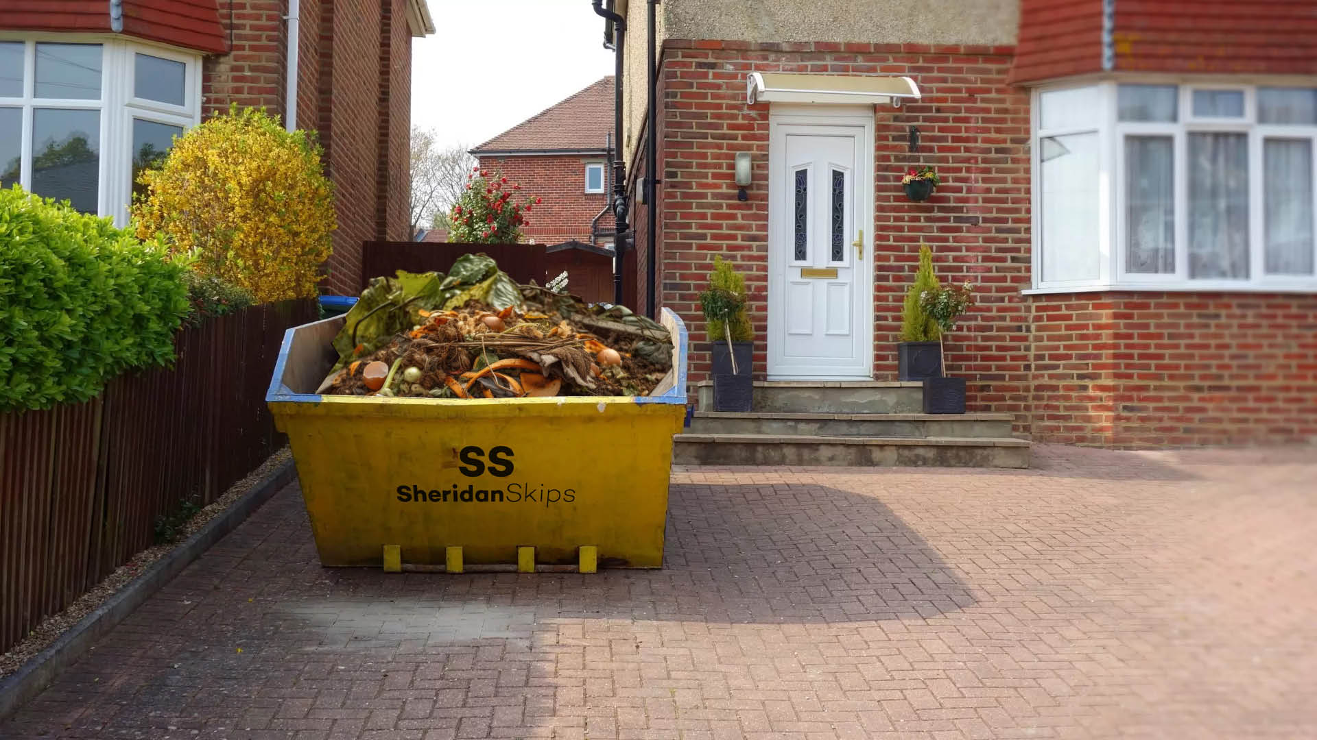 Sheridan Skip Lancashire skip with garden waste in it